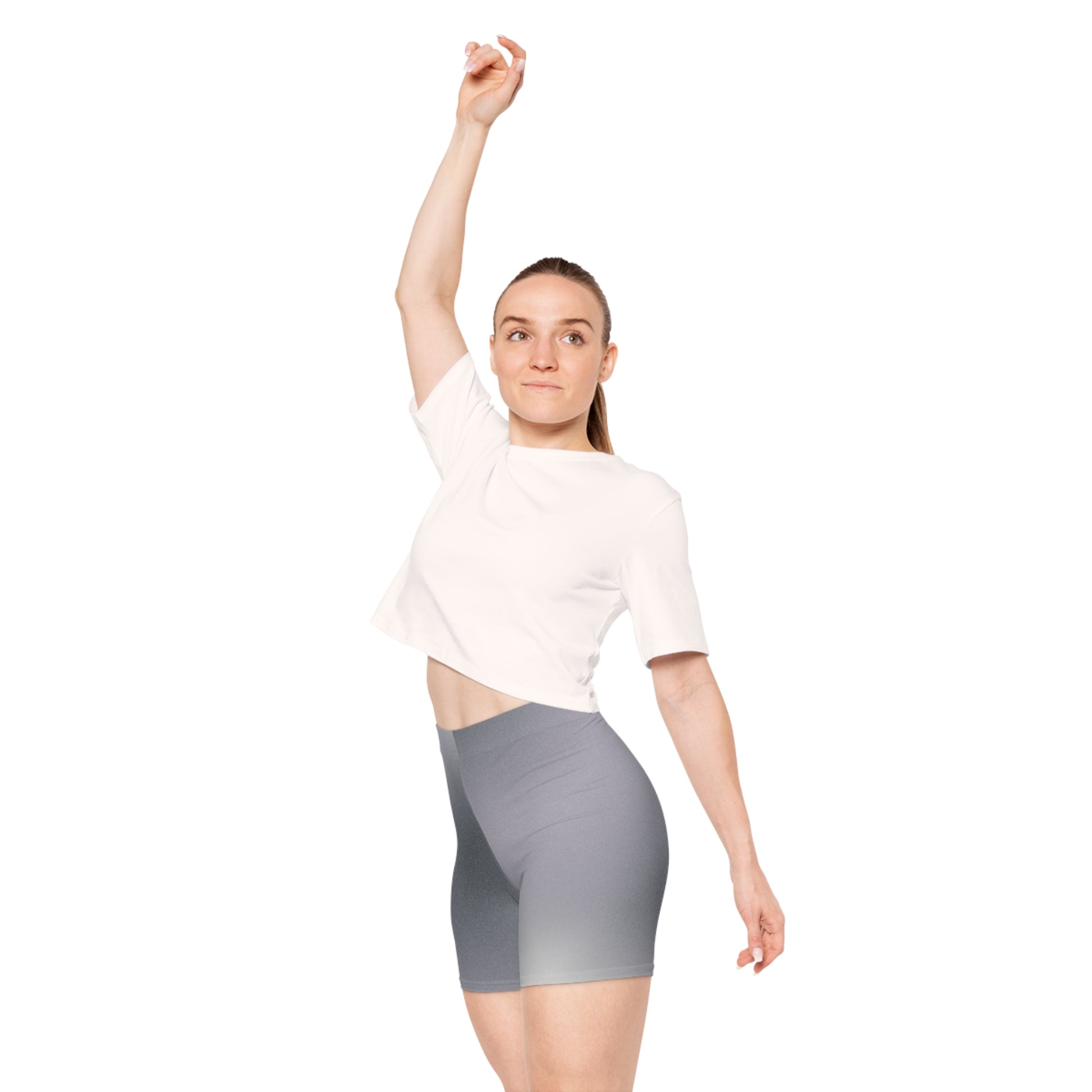 A female wearing a short white shirt and high-waisted gray ombre shorts, blending from dark to light gray. The pose showcases the shorts' snug fit and non-linear gradient design and with right hand raised reveals part of her stomach area. Makes a great gift for women.